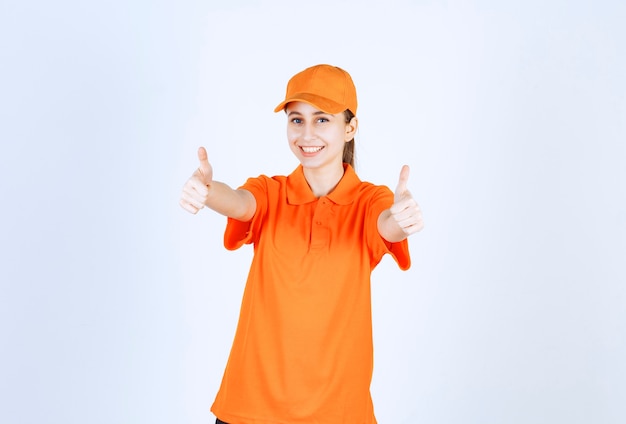 Female courier wearing orange uniform and cap showing thumb up