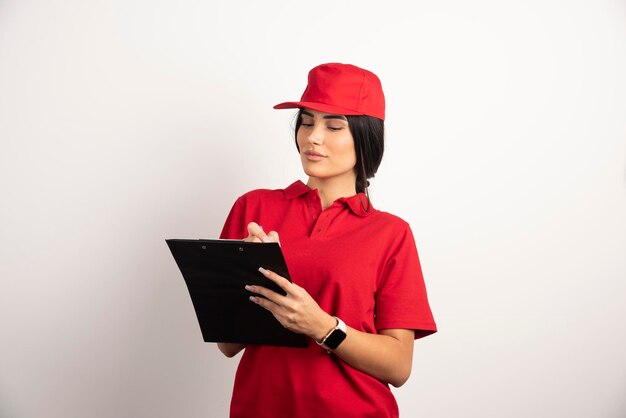 Female courier writing orders on clipboard. High quality photo