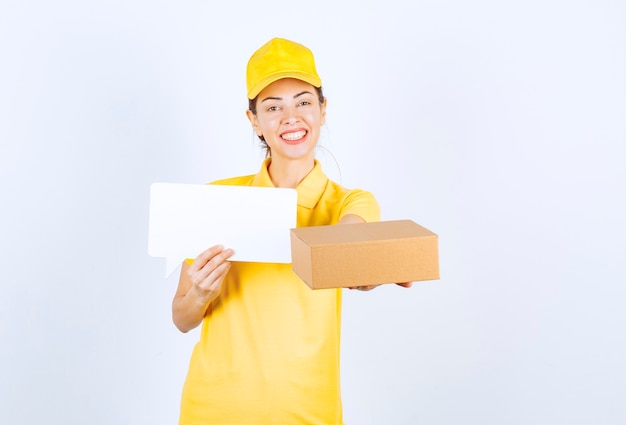 Female courier in yellow uniform offering the order to the customer and presenting the certificate of authenticity. 