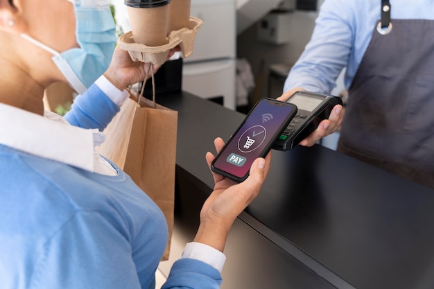 Free photo female customer paying for takeaway food with smartphone