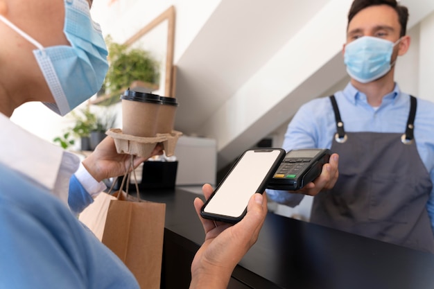 Female customer paying for takeaway food with smartphone