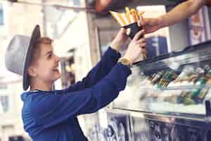 Free photo female customer reaching food from vendor