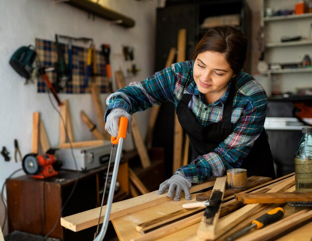 Female cutting wood plank