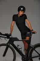 Free photo female cyclist wearing helmet and posing with bicycle