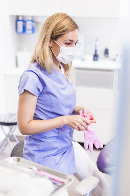 Free photo female dentist wearing gloves in clinic