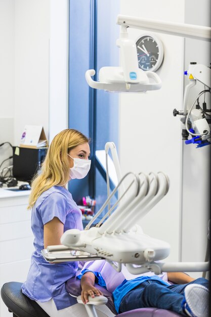 Female dentist wearing surgical mask in clinic