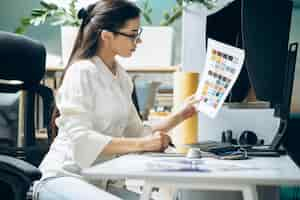 Free photo female digital designer looking at swatches at an office