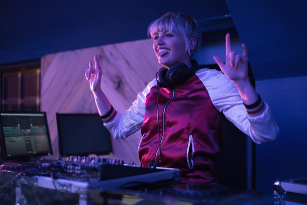 Female dj having fun while playing music in bar