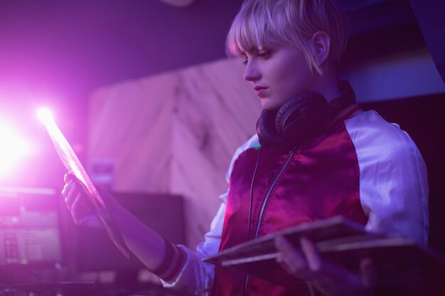 Female dj holding a vinyl disc record in bar