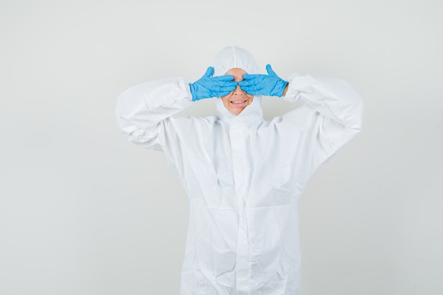 Free photo female doctor covering eyes with hands in protective suit