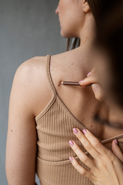 Free photo female doctor diagnosing a melanoma on the body of a female patient