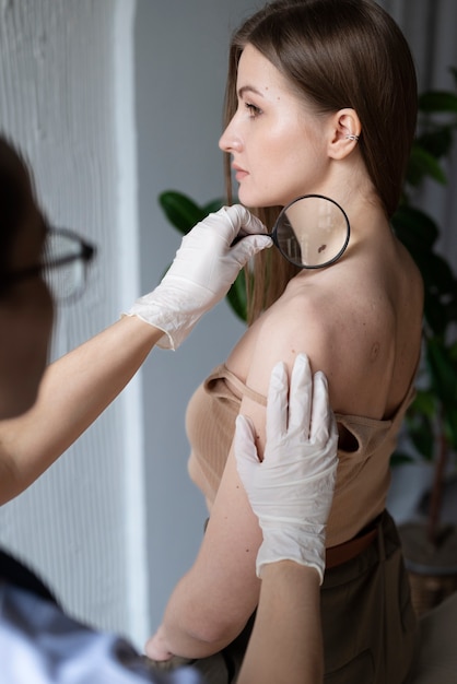 Free photo female doctor diagnosing a melanoma on the body of a female patient