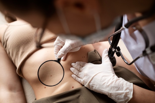 Free photo female doctor diagnosing a melanoma on the body of a female patient