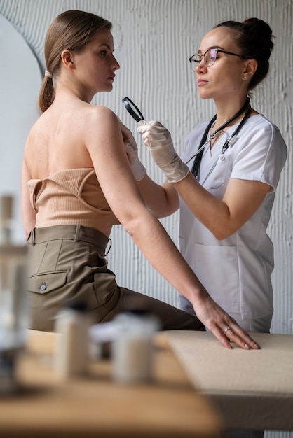 Free photo female doctor diagnosing a melanoma on the body of a female patient