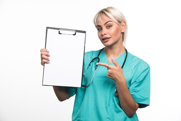 Female doctor holding a clipboard pointing finger on white surface