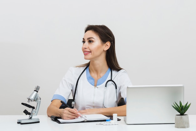 Female doctor holding a pen and looking away