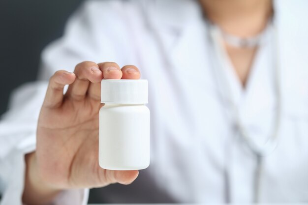 female doctor holding and showing a medicine bottle