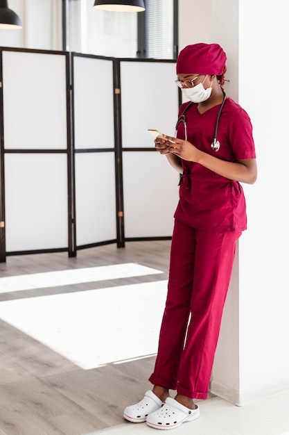 Free Photo female doctor leaning on a wall