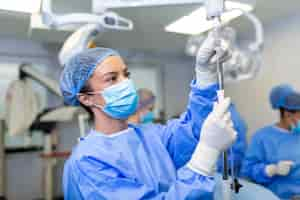 Free photo female doctor in the operating room putting drugs through an iv surgery concepts