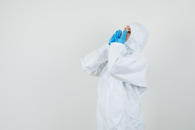 Female doctor in protective suit, gloves shouting or announcing something