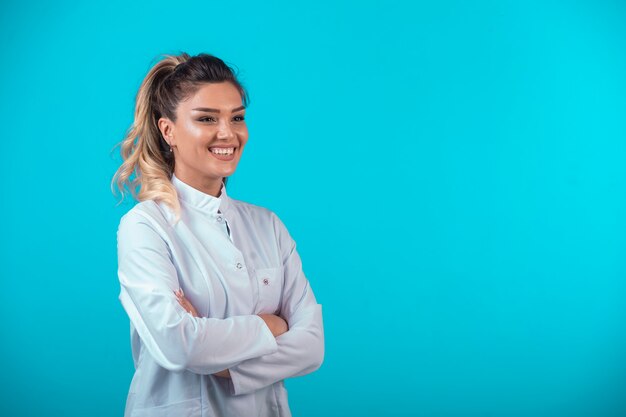 Female doctor in white uniform smiling. 