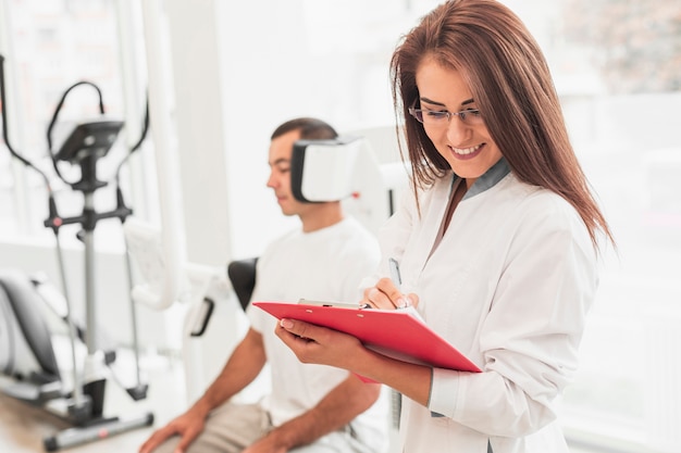 Female doctor writing on clipboard