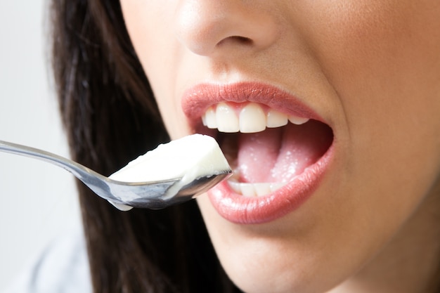 Female eating yogurt with spoon