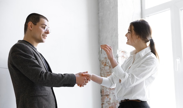 Female estate agent showing new home to a young man after a discussion on house plans moving new home concept