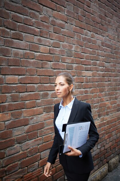 Female executive walking and holding a clipboard