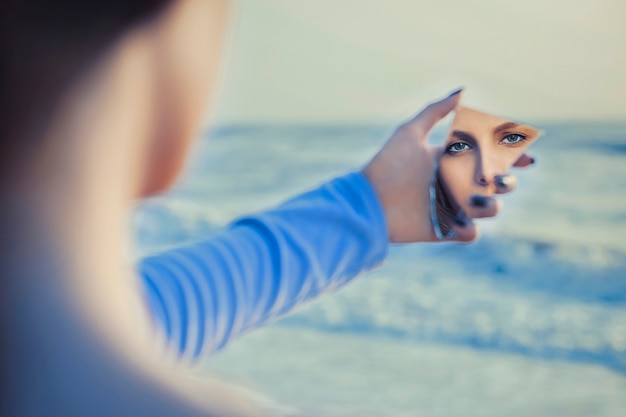 Free photo female fair haired model in mirror looking herself