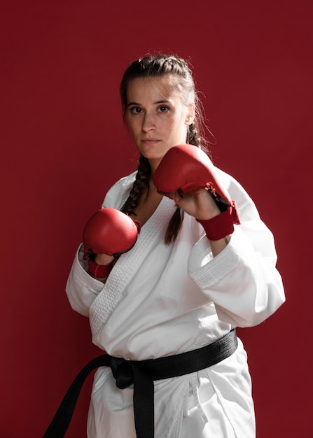 Free photo female fighter with box gloves on red background