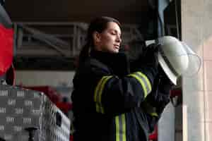 Free photo female firefighter putting on safety helmet