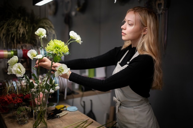 Free photo female florist making a beautiful arrangement of flowers