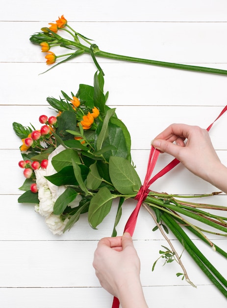 Free Photo female florist making beautiful bouquet at flower shop