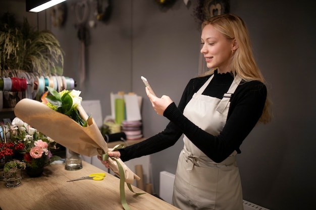 Female florist taking a photo of a fresh made bouquet