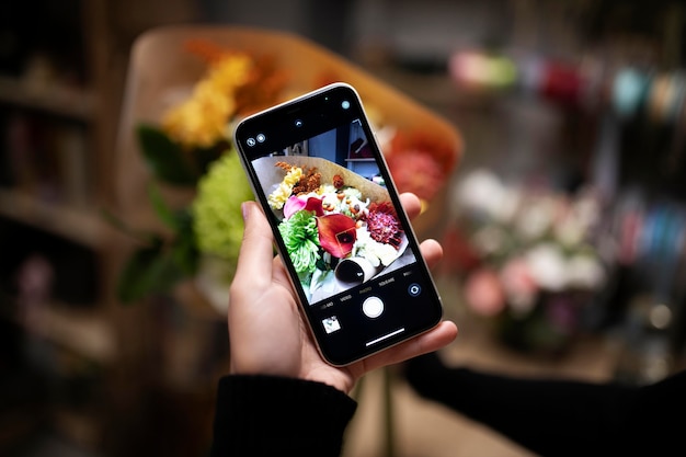 Female florist taking a photo of a fresh made bouquet