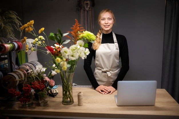 Free photo female florist using a laptop at work