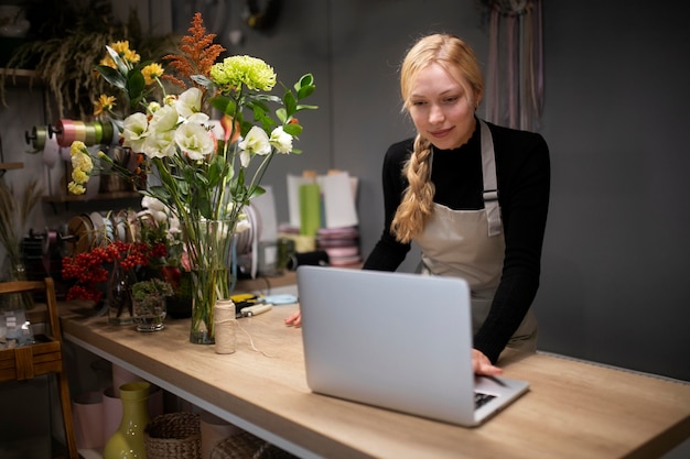 Free photo female florist using a laptop at work