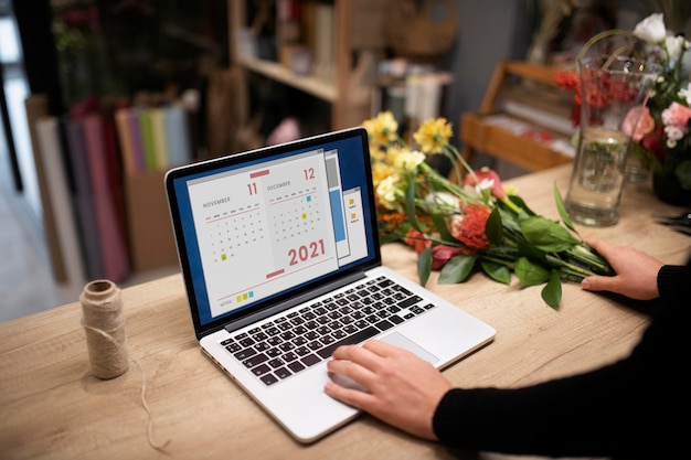 Free photo female florist using a laptop at work