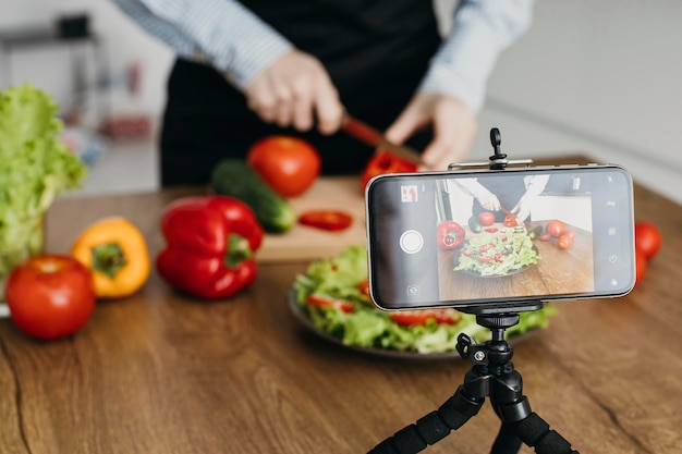 Free photo female food blogger streaming at home while cooking