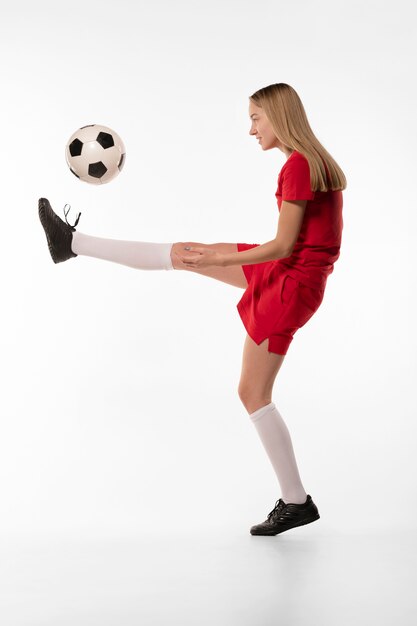 Female football player kicking ball