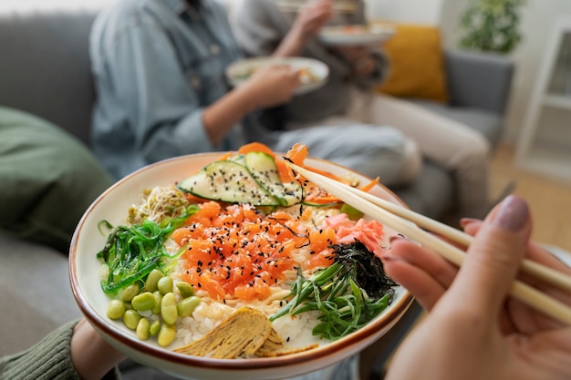 Free photo female friends eating seafood dish with salmon together