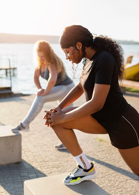 Female friends exercising together outside