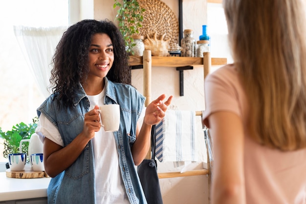 Female friends having a conversation over coffee in the kitchen