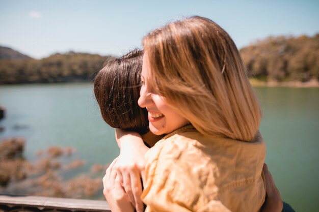 Female friends hugging near river