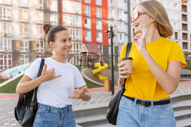 Female friends outside using sign language