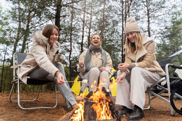 Female friends roasting marshmallows using a bonfire