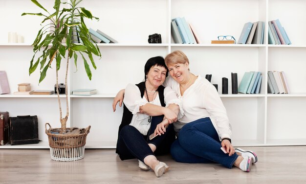 Female friends sitting on the floor and plant