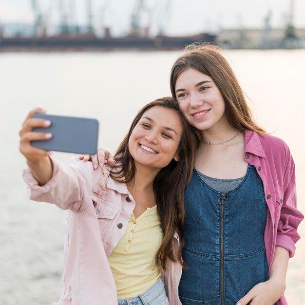 Female friends taking selfie by the lake