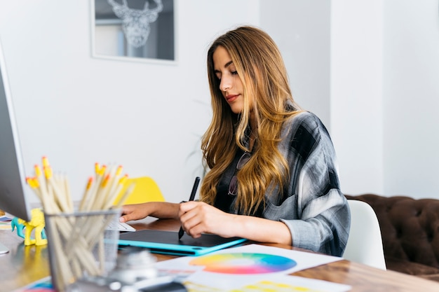 Free photo female graphic designer at desk